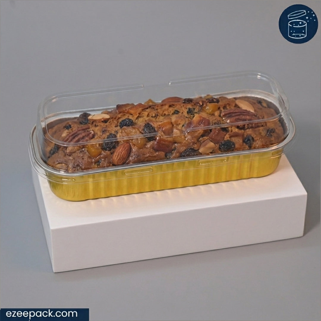 A rectangular loaf of fruit and nut bread in a clear plastic clamshell container with a yellow base, displayed on a white pedestal against a gray background.
